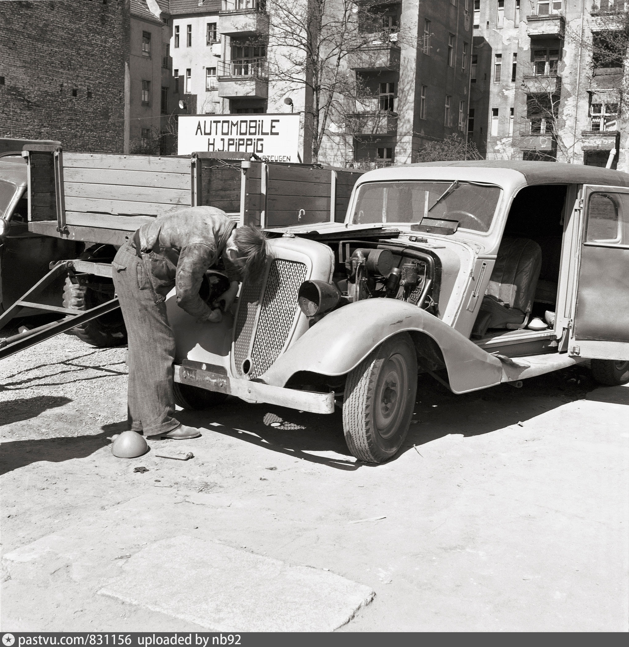 A mechanic repairs an old car