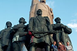 Молодий чоловік з українським прапором біля пам'ятника (1991)